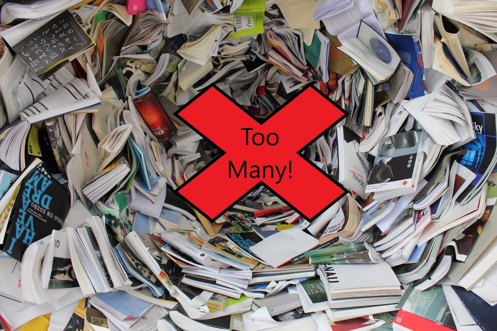 A large pile of scattered magazines and papers with a red X and the text 'Too Many!' in the center.